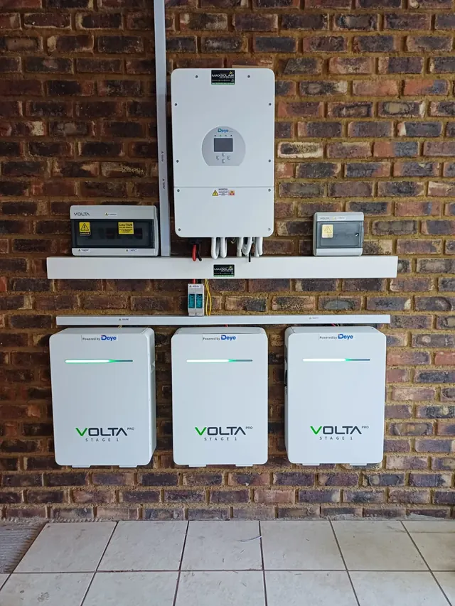 Residential Installation: A wall-mounted Deye inverter with Volta battery storage and Maxsolair-branded cable management on a brick wall.